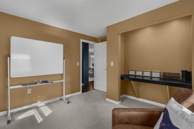 interior space featuring a textured ceiling and baseboards