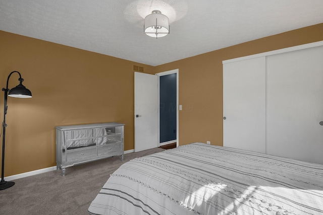 carpeted bedroom featuring a closet, visible vents, a textured ceiling, and baseboards