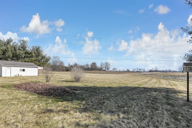 view of yard featuring a rural view and an outdoor structure