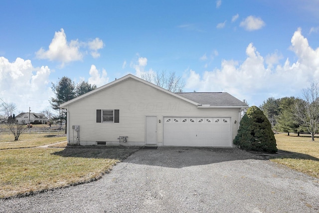 view of side of property featuring driveway, an attached garage, and a lawn