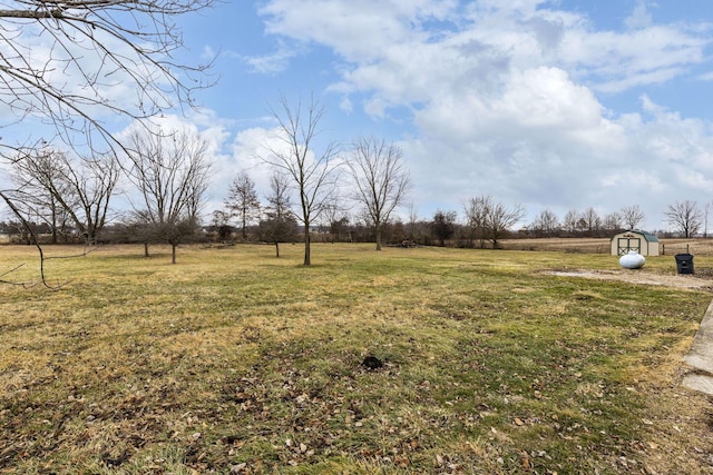 view of yard with a rural view and a storage unit