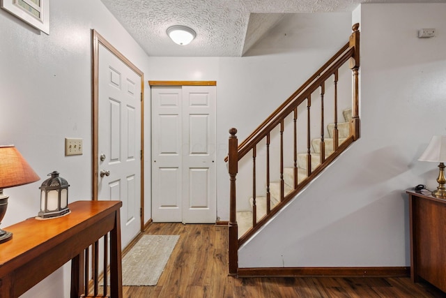 entrance foyer with dark hardwood / wood-style floors and a textured ceiling