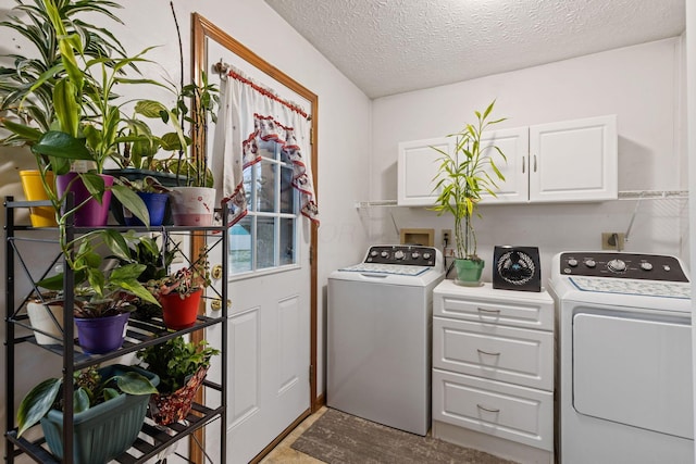 laundry area featuring cabinets, separate washer and dryer, and a textured ceiling