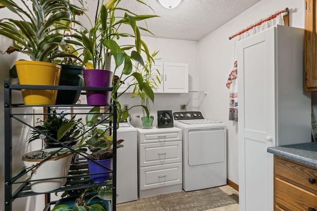 washroom featuring cabinets, separate washer and dryer, and a textured ceiling