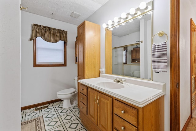 bathroom featuring vanity, toilet, and a textured ceiling