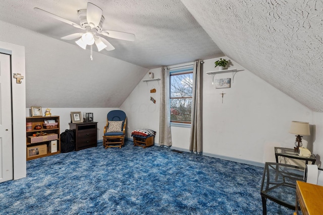 interior space featuring ceiling fan, lofted ceiling, dark carpet, and a textured ceiling