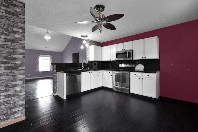 kitchen with white cabinetry, appliances with stainless steel finishes, pendant lighting, and kitchen peninsula