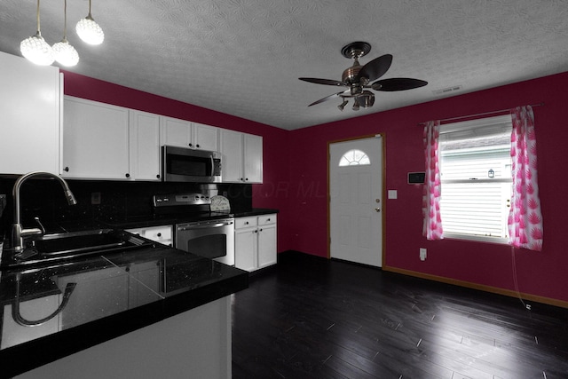 kitchen featuring sink, hanging light fixtures, dark hardwood / wood-style floors, stainless steel appliances, and white cabinets