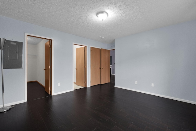 spare room with dark hardwood / wood-style flooring, electric panel, and a textured ceiling