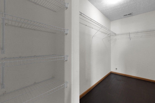 walk in closet with hardwood / wood-style floors