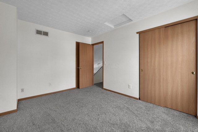 unfurnished bedroom featuring carpet flooring, a textured ceiling, and a closet