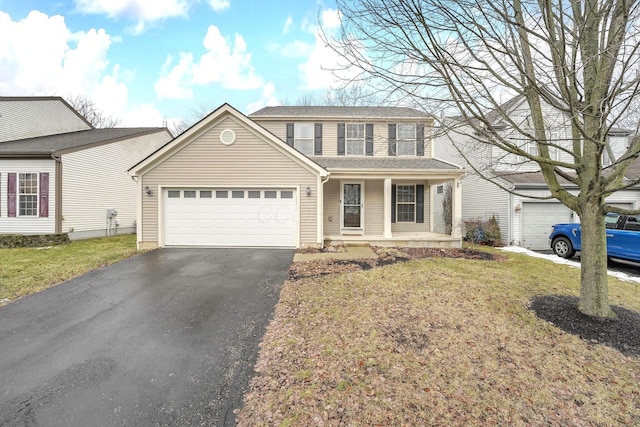 traditional home with a porch, a front lawn, driveway, and a garage