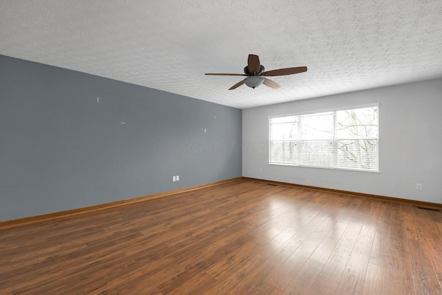 spare room featuring a ceiling fan, wood-type flooring, a textured ceiling, and baseboards