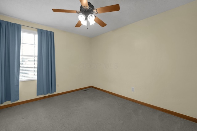 spare room featuring carpet floors, baseboards, and a ceiling fan