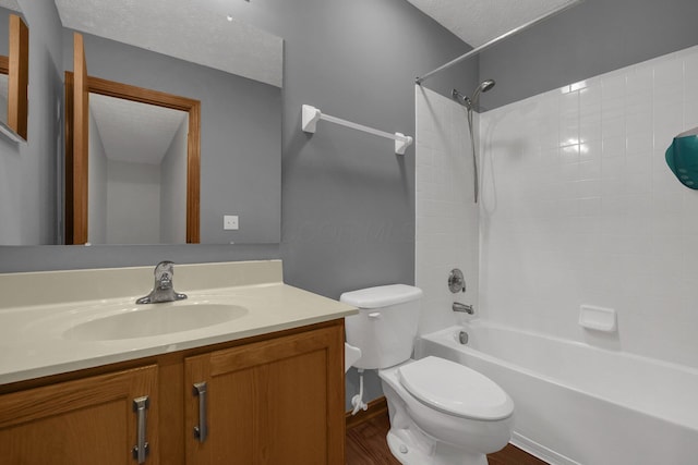 full bath with shower / washtub combination, toilet, a textured ceiling, vanity, and wood finished floors