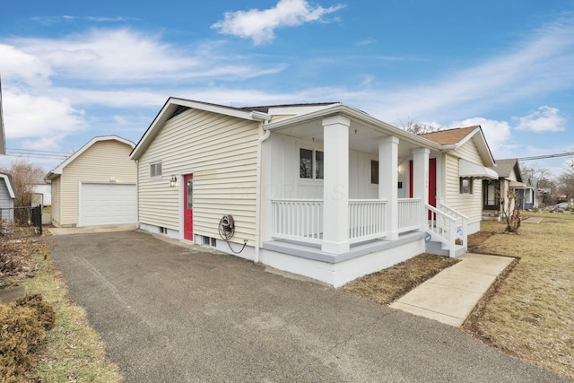 view of front of home featuring a garage, an outdoor structure, and covered porch