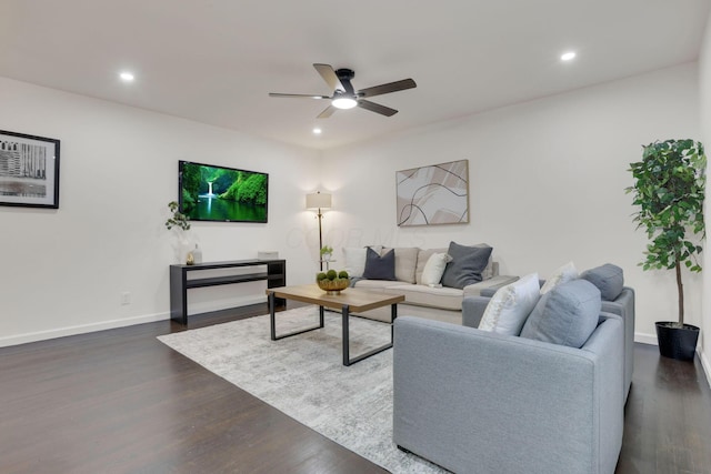 living room with ceiling fan and dark hardwood / wood-style flooring