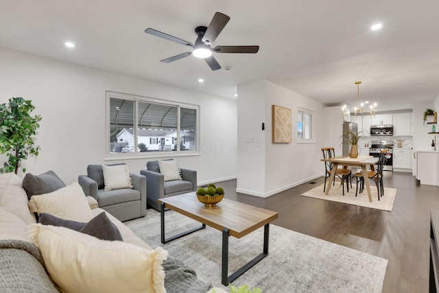 living room featuring dark hardwood / wood-style flooring and ceiling fan with notable chandelier