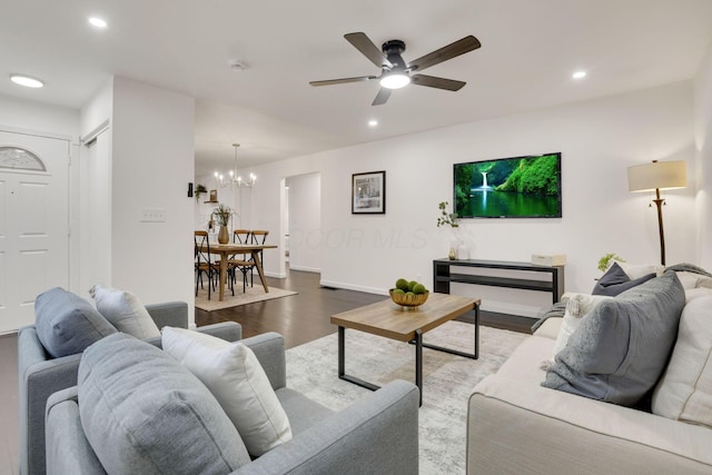 living room featuring wood-type flooring and ceiling fan with notable chandelier