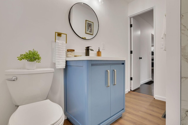 bathroom with wood-type flooring, toilet, and vanity