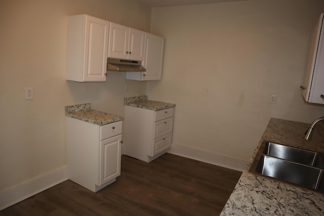 kitchen featuring light stone counters, sink, dark hardwood / wood-style floors, and white cabinets