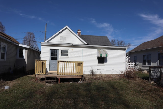 rear view of property featuring a deck and a lawn