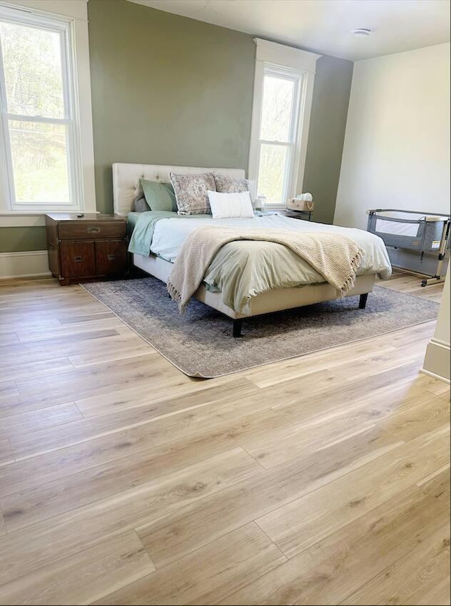 bedroom with multiple windows and light wood-type flooring