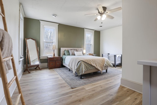 bedroom featuring multiple windows, ceiling fan, and light wood-type flooring