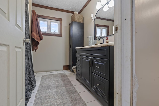 full bath featuring a textured ceiling, plenty of natural light, tile patterned flooring, and vanity