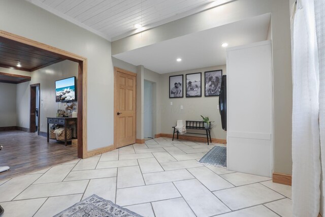 hallway featuring light tile patterned floors and ornamental molding