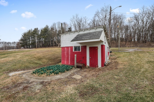 view of outbuilding with a yard