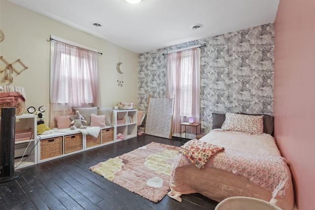 bedroom featuring multiple windows and dark hardwood / wood-style flooring