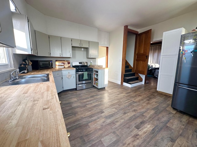 kitchen with dark wood finished floors, appliances with stainless steel finishes, light countertops, and a sink