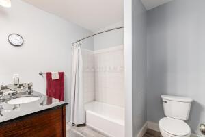 full bathroom with vanity, shower / bath combination with curtain, and toilet