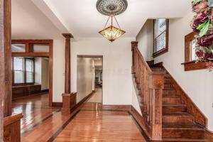 staircase featuring hardwood / wood-style floors and ornate columns