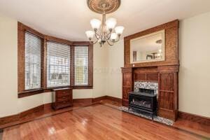 unfurnished living room featuring hardwood / wood-style floors and a notable chandelier