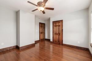 unfurnished room with ceiling fan and wood-type flooring