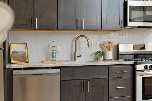 kitchen featuring appliances with stainless steel finishes, sink, backsplash, and dark brown cabinetry