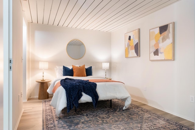 bedroom with wooden ceiling and light wood-type flooring