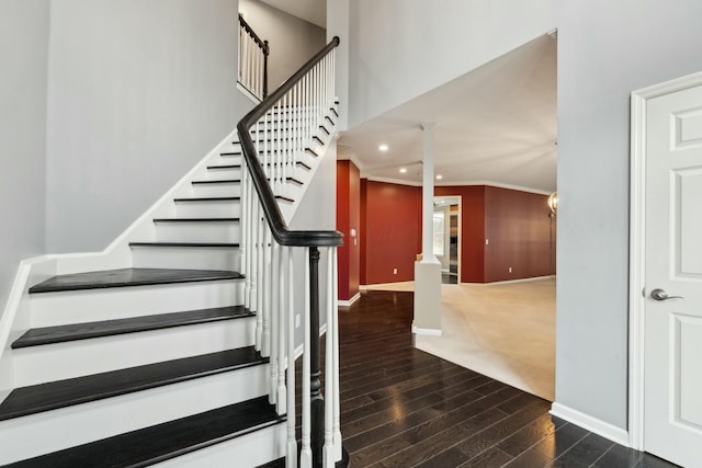 staircase featuring decorative columns, wood-type flooring, and ornamental molding