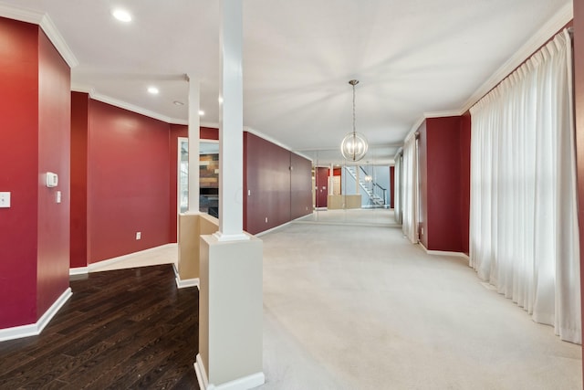 corridor featuring ornamental molding, a chandelier, wood-type flooring, and ornate columns