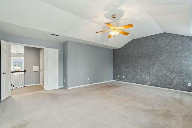 carpeted spare room featuring vaulted ceiling and ceiling fan