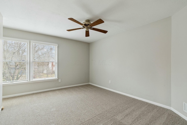 carpeted spare room with ceiling fan