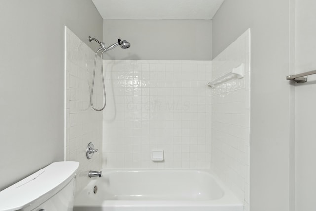 bathroom with tiled shower / bath combo, a textured ceiling, and toilet