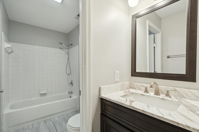 full bathroom with tiled shower / bath combo, vanity, and toilet