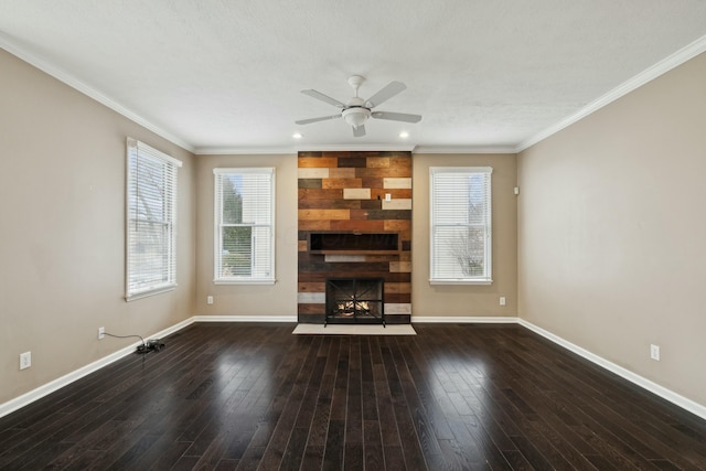 unfurnished living room with dark wood-type flooring, a large fireplace, ornamental molding, and ceiling fan