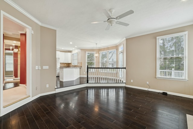 unfurnished living room with crown molding, ceiling fan, wood-type flooring, and sink