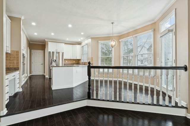 kitchen featuring pendant lighting, dark hardwood / wood-style flooring, stainless steel fridge with ice dispenser, and white cabinets