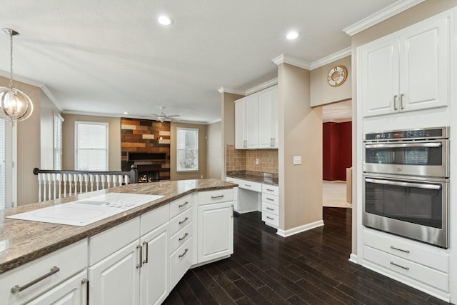 kitchen featuring stainless steel double oven, dark hardwood / wood-style flooring, hanging light fixtures, and white cabinets