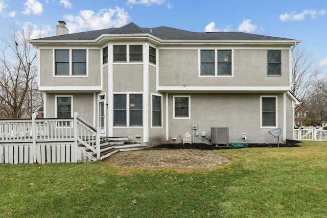 rear view of property featuring a yard, central AC unit, and a patio area